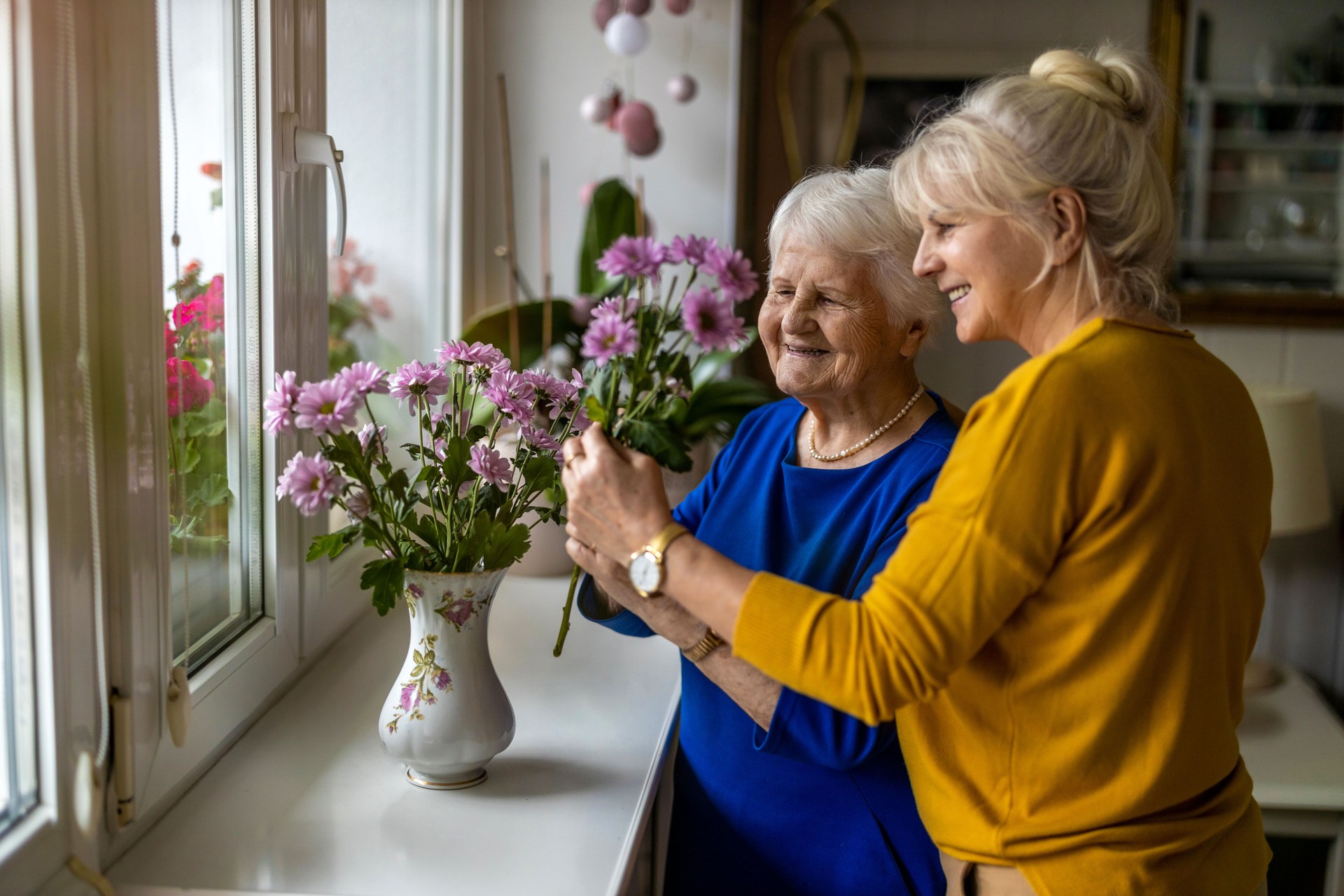 Woman spending time with her elderly mother at home