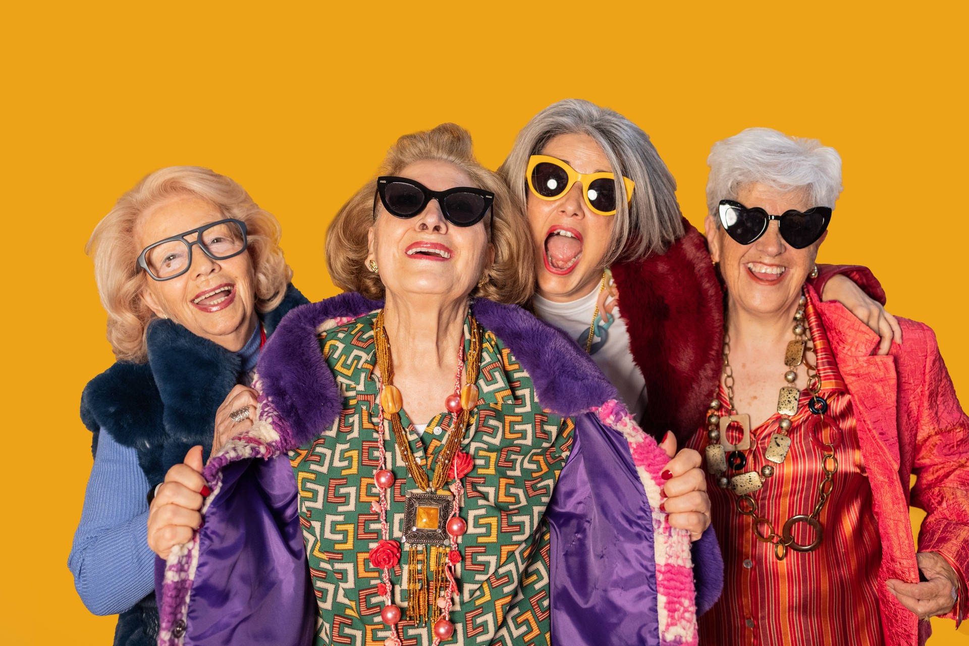 Four fashionable senior women smiling and having fun