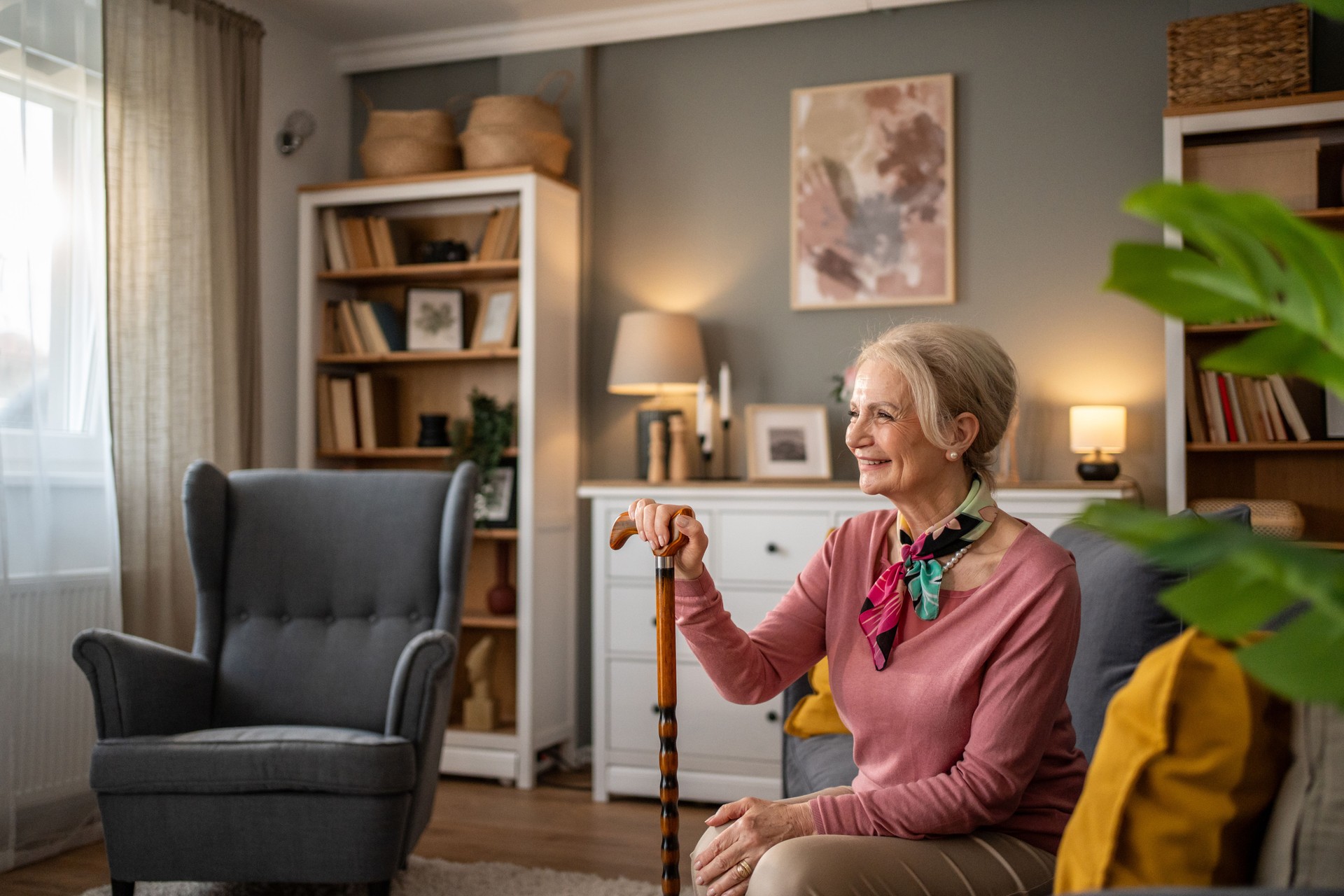 Happy senior woman smiling and holding walking cane at home
